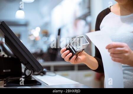 vendeur, shoppiline donnant un cachet sur un reçu, facture pour un client, temps de vente, période de remise, concept financier Banque D'Images