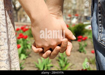 Couple tenant les mains sur fond flou Banque D'Images