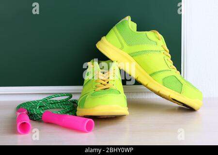 Chaussures de sport et corde à sauter sur fond de tableau noir Banque D'Images