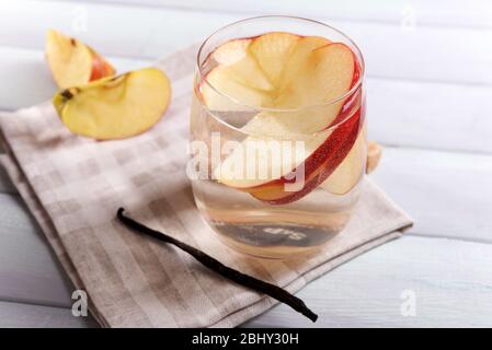 Verre de cidre de pomme avec fruits et bâton de vanille sur la table près Banque D'Images