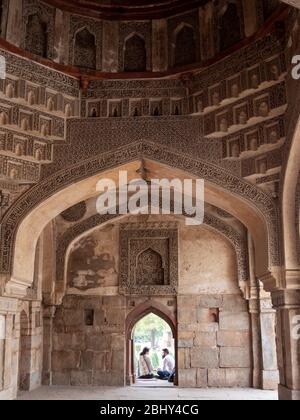 DELHI, INDE - 13 MARS 2019: Vue intérieure d'une fenêtre de gumbad bara et d'un couple indien assis dessus Banque D'Images