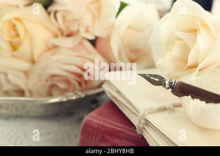 Roses fraîches avec vieux livre et lettres sur fond de table en bois couleur. Concept vintage Banque D'Images