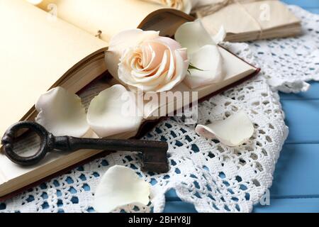 Roses fraîches avec vieux livre et lettres sur fond de table en bois couleur. Concept vintage Banque D'Images