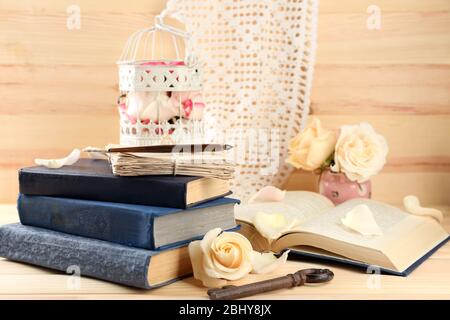 Roses fraîches avec vieux livre, clé et lettres sur fond de table en bois. Concept vintage Banque D'Images