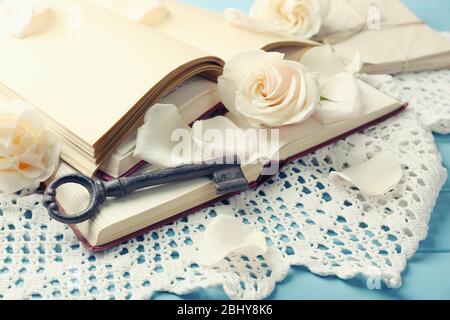 Roses fraîches avec vieux livre et lettres sur fond de table en bois couleur. Concept vintage Banque D'Images