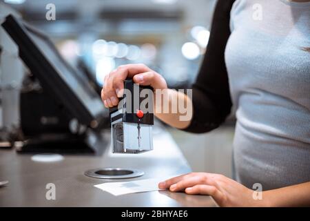 Jeune femme fait main de paiement de processus, obtenir le timbre avec la vente à recevoir dans l'immense centre commercial, concept de financement Banque D'Images