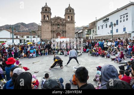 Artistes de rue qui divertit les habitants en face de l'église Saint-Pierre dans la Plazoleta San Pedro, Cusco, Pérou Banque D'Images