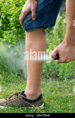 Jeune homme vaporisant des moustiques, des insectes dans le repos, la protection des insectes, le concept d'hélices Banque D'Images