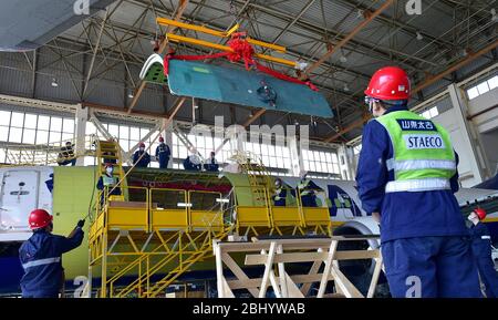 (200428) -- JINAN, le 28 avril 2020 (Xinhua) -- les techniciens rénovent un avion de ligne à Taikoo (Shandong) Aircraft Engineering Company Limited (STAECO) à Jinan, dans la province de Shandong en Chine orientale, le 27 avril 2020. La pandémie COVID-19 a entraîné une diminution importante des revenus des passagers et des voyages aériens. Depuis sa récupération de sa production le 10 février, STAECO offre des solutions de transport de passagers à fret (PTF) aux exploitants de compagnies aériennes qui ont besoin de plus d'avions de fret pour faire face à ce changement de marché. Jusqu'à présent, la société a effectué trois conversions PTF pour ses clients. (Xinhua/Zhu Zheng) Banque D'Images