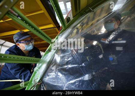 (200428) -- JINAN, le 28 avril 2020 (Xinhua) -- les techniciens rénovent un avion de ligne à Taikoo (Shandong) Aircraft Engineering Company Limited (STAECO) à Jinan, dans la province de Shandong en Chine orientale, le 27 avril 2020. La pandémie COVID-19 a entraîné une diminution importante des revenus des passagers et des voyages aériens. Depuis sa récupération de sa production le 10 février, STAECO offre des solutions de transport de passagers à fret (PTF) aux exploitants de compagnies aériennes qui ont besoin de plus d'avions de fret pour faire face à ce changement de marché. Jusqu'à présent, la société a effectué trois conversions PTF pour ses clients. (Xinhua/Zhu Zheng) Banque D'Images