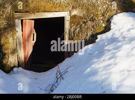 Porte de cave à racine à moitié ouverte et neige bloquant la voie, Finlande Banque D'Images