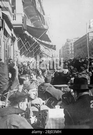 La guerre - mais la vie continue. - malgré l'évolution de la situation de guerre, Burgos, siège du gouvernement provisoire des rebelles espagnols, est une ville gay. Non seulement c'est le centre animé de l'administration du général Franco, mais c'est aussi un lieu de vacances pour les soldats insurgés en congé du front de bataille. - spectacles photo: Les soldats discutant des dernières nouvelles du front dans l'un des cafés en plein air sur les trottoirs bondés de Burgos. - 7 avril 1937 Banque D'Images