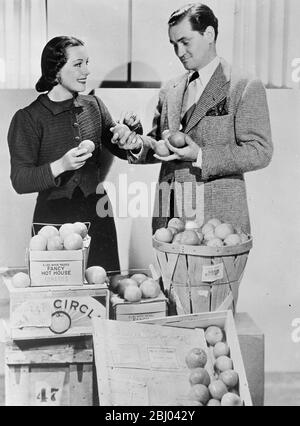 Elle voulait un avec la plupart 'quelch'. - Gladys Swarthout, célèbre chanteuse d'opéra et de films, avait l'une des demandes les plus étranges quand elle a cherché la tomate avec la chair la plus douce et la plus 'quelch'. La tomate était nécessaire pour son nouveau film dans lequel un membre hostile de l'audience la jette dans son visage. Des centaines de tomates, envoyées par avion de toutes les régions du pays à Hollywood, à l'indignation des chambres de commerce de Los Angeles et d'Hollywood. - spectacles de photos, Gladys Swarthout avec son mari et Manager, Frank Chapman, en sélectionnant la tomate appropriée d'un envoi envoyé par air de Banque D'Images