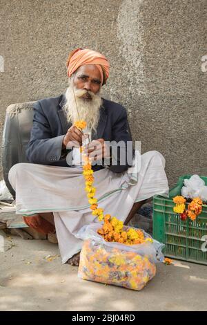 Portrait d'un homme qui vend des guirlandes de fleurs sur le marché Banque D'Images