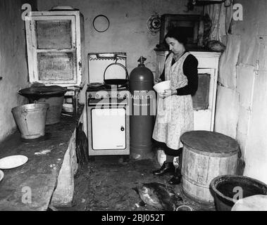 Mme Peters est allée à la ferme en 1916 avec son mari. Maintenant veuve, elle est 59, mais semble beaucoup plus jeune. Elle gère très avec l'aide de ses deux frères. - C'est sa cuisine - la seule commodité moderne étant le gaz en bouteille et la cuisinière - qui est apporté environ 13 miles chaque fois qu'une nouvelle bouteille est nécessaire. 1950 Banque D'Images