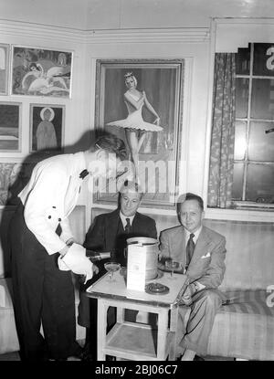 L'intérieur du Gargoyle Club dans Dean Street, Soho. Le serveur de vins René Rudio sert aux membres du club sous les peintures exposées par le personnel du club. - 23 mars 1949 Banque D'Images