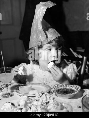 Della Anphlett , 6 ans , mange un gâteau de tasse à la fête de Noël Variety Club pour les enfants à l'orphelinat de Saint Agnes, Thames Ditton. - 15 Ennismore Gardens, Londres, Angleterre - 19 décembre 1959 Banque D'Images