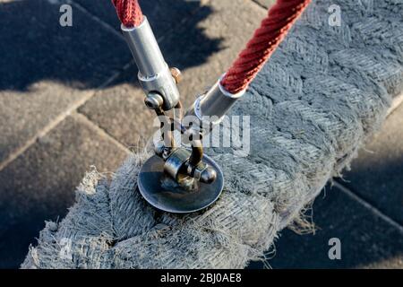 Détail de la poignée métallique, corde forte et corde d'amarrage d'une balançoire pour enfants en diagonale, coupant l'image de vue à grand angle. Banque D'Images