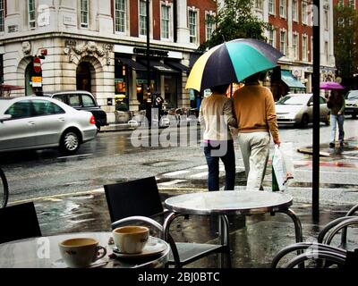 Scène de rue du café de Londres avec couple sous un parasol de golf - Banque D'Images