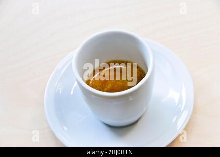 Tasse en porcelaine blanche de café espresso fraîchement préparé raquette « crème » - Banque D'Images