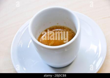 Tasse en porcelaine blanche de café espresso fraîchement préparé raquette « crème » - Banque D'Images