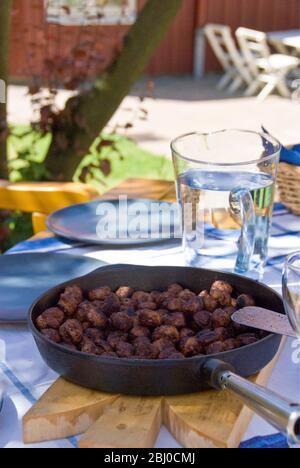 Poêle à frire de boulettes de viande suédoises sur la table à l'extérieur, sous le soleil d'été - Banque D'Images