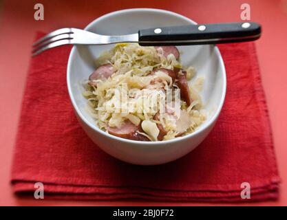 Petit plat blanc de sauerkraut allemand avec morceaux de saucisse fumé - Banque D'Images