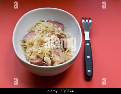 Petit plat blanc de sauerkraut allemand avec morceaux de saucisse fumé - Banque D'Images