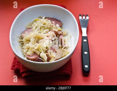 Petit plat blanc de sauerkraut allemand avec morceaux de saucisse fumé - Banque D'Images