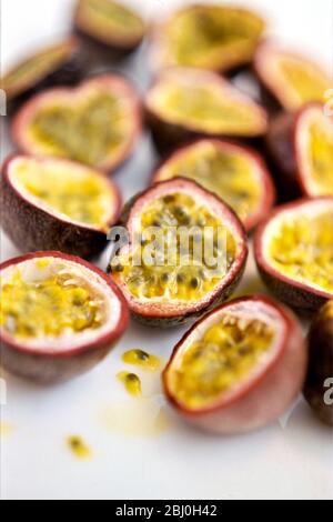 Fruits de passion mûrs coupés en deux sur surface blanche - Banque D'Images
