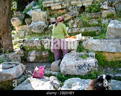 Femme pressant les oranges pour vendre des verres de jus frais aux touristes dans l'ancien amphithéâtre grec, sud de la Turquie - Banque D'Images