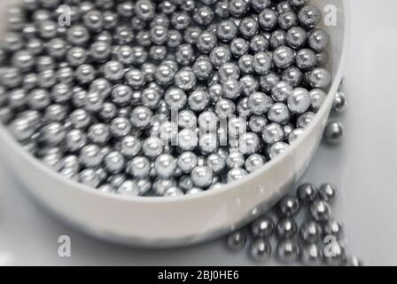 Boules argentées comestibles pour la décoration de gâteaux, tir avec lentille Lensbaby pour effet de bordure flou - Banque D'Images