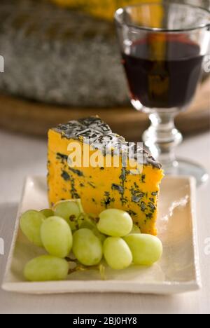 Blacksticks Blue Cheese de Lancashire UK, servi sur plaque avec des raisins et un verre de vin rouge - Banque D'Images