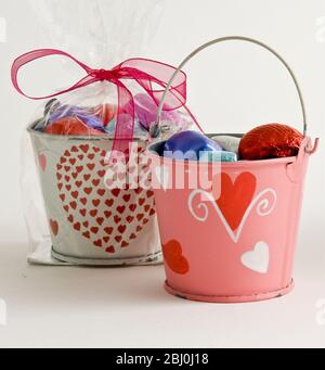 Petits seaux, peints avec des coeurs, remplis de chocolats comme cadeaux de Saint-Valentin, - Banque D'Images