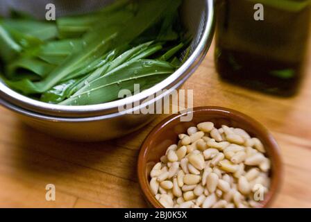 Ingrédients pour pesto d'ail sauvage, feuilles d'ail sauvage lavées, pinenuts dans un petit bol. Prise de vue avec objectif Lensbaby pour un effet de flou sur les bords. - Banque D'Images