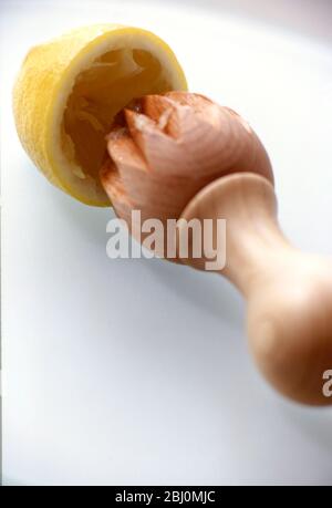 Alésoir au citron avec un demi-citron sur la surface blanche - Banque D'Images