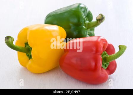 Trois poivrons doux brillants, rouge, vert et jaune - Banque D'Images