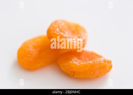 Trois abricots secs sur la surface blanche - Banque D'Images