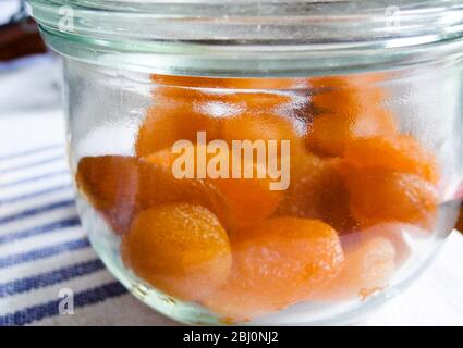 jat en verre d'abricots secs sur la table de cuisine - Banque D'Images