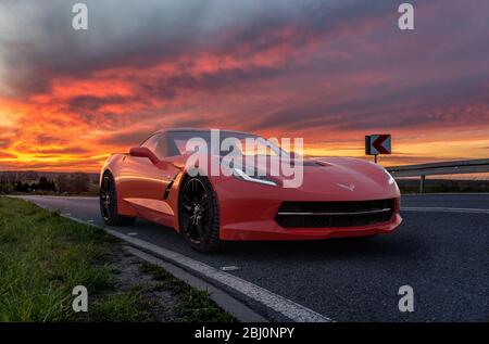 Chevrolet Corvette C 7 sur la route pendant un coucher de soleil spectaculaire Banque D'Images