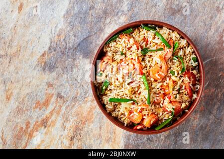 Riz frit asiatique aux crevettes œufs brouillés et oignons de printemps avec sauce thaï sur fond de pierre en marbre, vue sur le dessus, espace de copie Banque D'Images