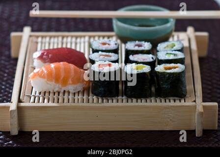 Sushi et sashimi sur plateau japonais en bambou avec sauce soja - Banque D'Images