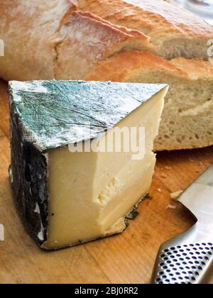 Fromage Cornish Yarg avec couverture de bouilloires à bord avec pain croustillant et couteau. - Banque D'Images