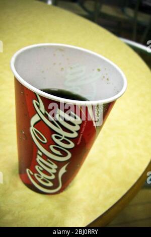 Tasse de papier de Coca-Cola sur table jaune dans le restaurant de services d'autoroute - Banque D'Images