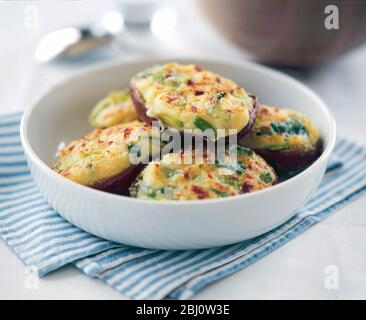 Pommes de terre cuites avec deux pommes de terre cuites avec de la garniture de fromage et des oignons de printemps - Banque D'Images