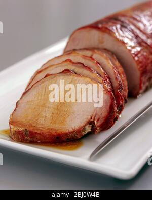 Filet de porc rôti sur plaque blanche - Banque D'Images