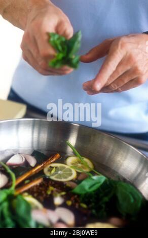 Gordon Ramsay faire une eau aromatisée pour cuire du saumon - Banque D'Images