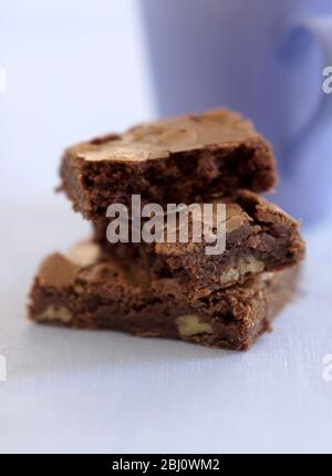 Brunes au chocolat en pile avec mug mauve - Banque D'Images