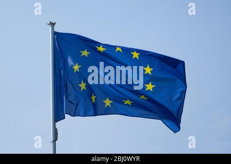 Drapeau de l'Union européenne isolé sur un ciel bleu clair agitant sur le vent Banque D'Images