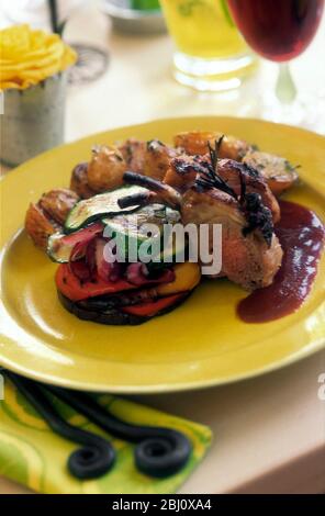 Rôti d'agneau sur des légumes rôtis mélangés avec sauce sur plaque jaune dans le cadre de la fête du déjeuner - Banque D'Images